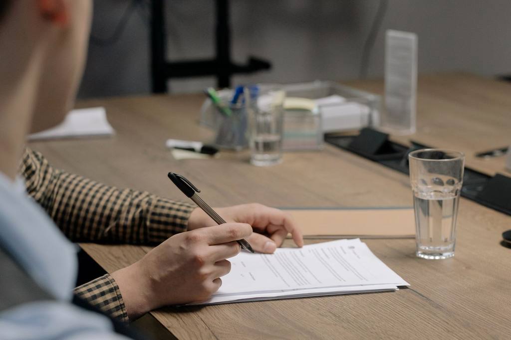 Builder reviewing architectural plans on a wooden table with tools